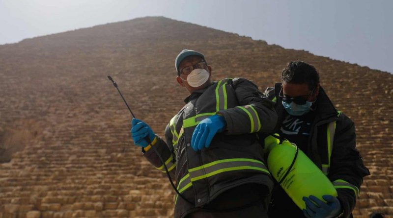 Медики проводят дезинфекцию возле пирамиды Хеопса в Гизе, Египет